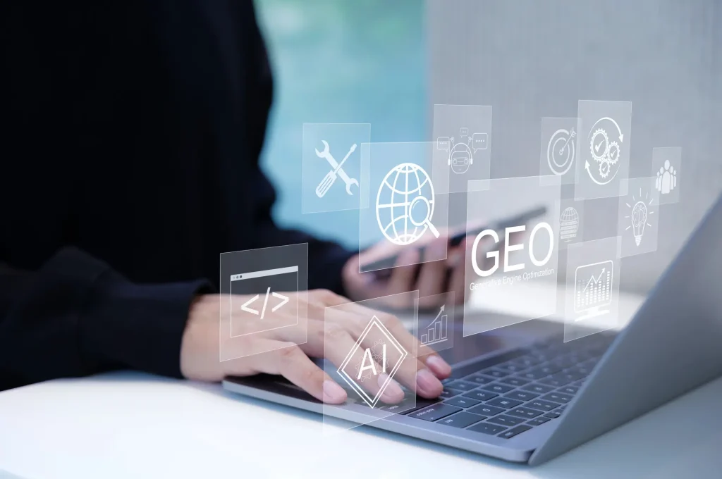 Close-up of a person typing on a laptop with floating digital icons representing generative engine optimization (GEO).