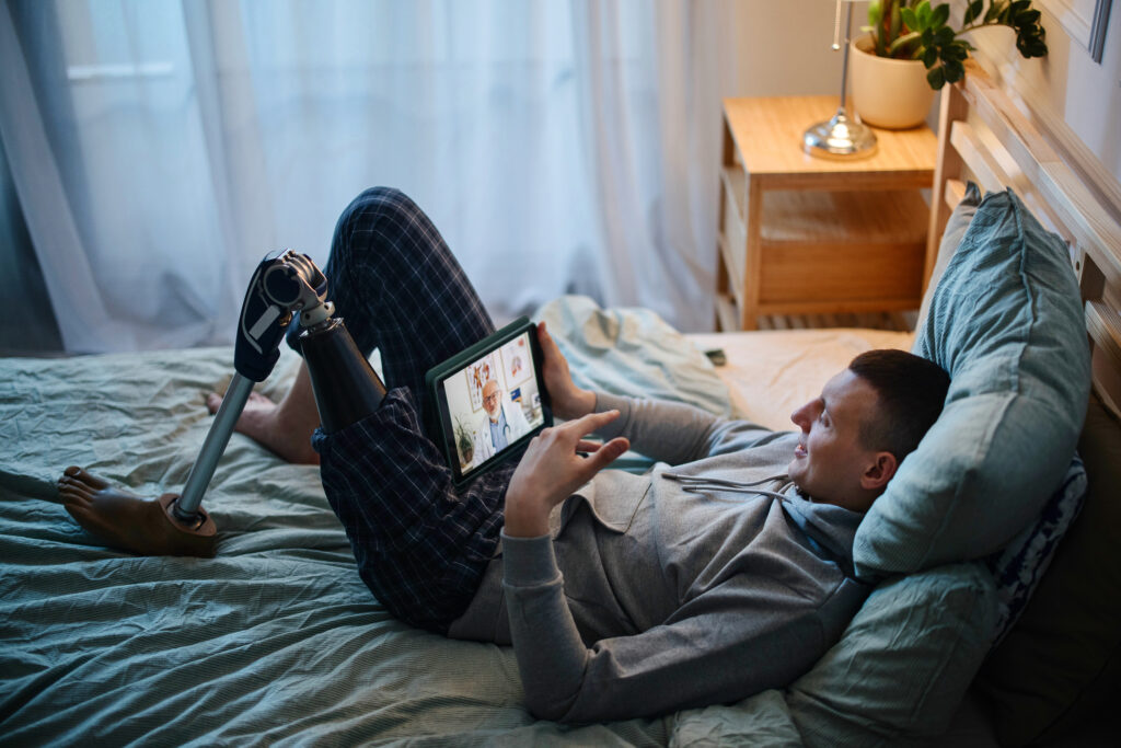 A man lying on a bed with a tablet