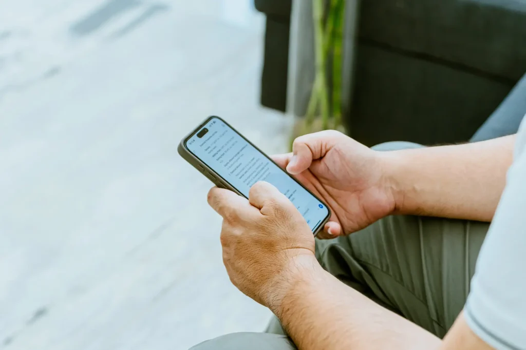 Person using Grok AI Chats on a smartphone while seated